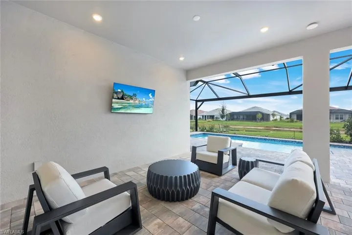 View of patio / terrace with a sunroom, an outdoor pool, a lanai, a residential view, and outdoor lounge area
