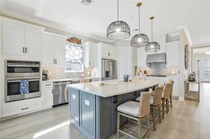 Kitchen featuring white cabinets, ornamental molding, a kitchen island, and a breakfast bar area