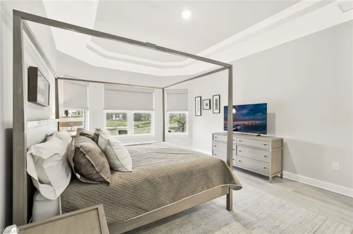 Bedroom featuring light wood finished floors and a tray ceiling