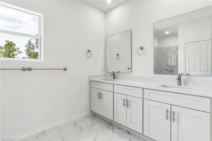Bathroom featuring tile flooring, a shower, and double sink vanity