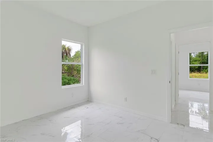Empty room with a healthy amount of sunlight and light tile floors