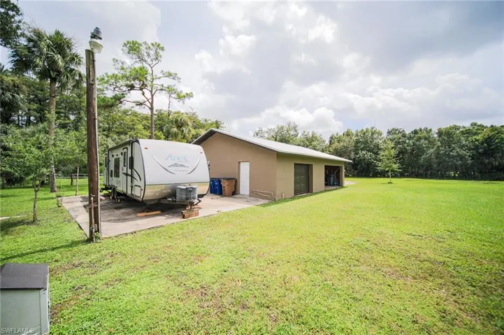 View of green lawn featuring an outdoor structure