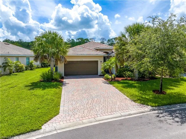 View of front of house with a garage and a front yard