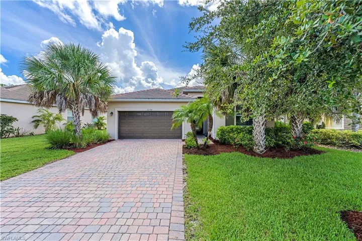 View of front of property with a garage and a front lawn