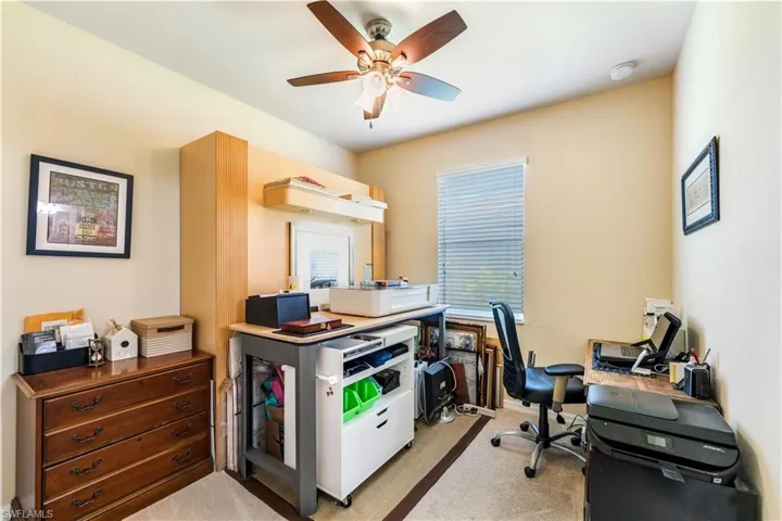 Office area with ceiling fan and light colored carpet