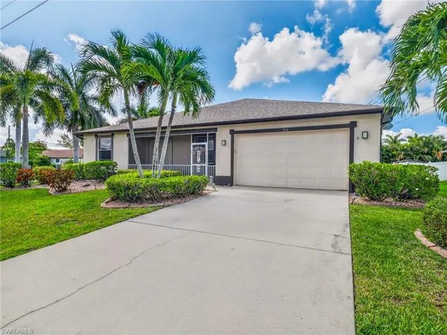 Single-story residence featuring a concrete driveway and an attached garage with a panel door