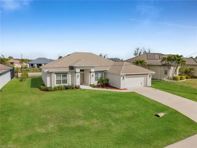 View of front facade featuring a front lawn, a garage, stucco siding, concrete driveway, and a shingled roof