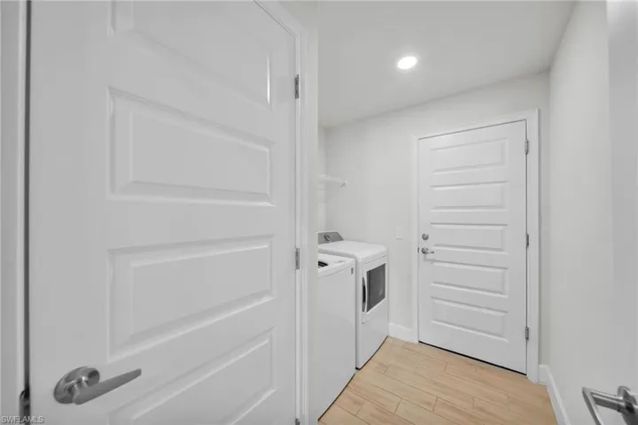Laundry room with recessed lighting, light wood-type flooring, and separate washer and dryer