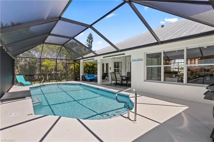 Outdoor pool with a patio area, ceiling fan, and glass enclosure
