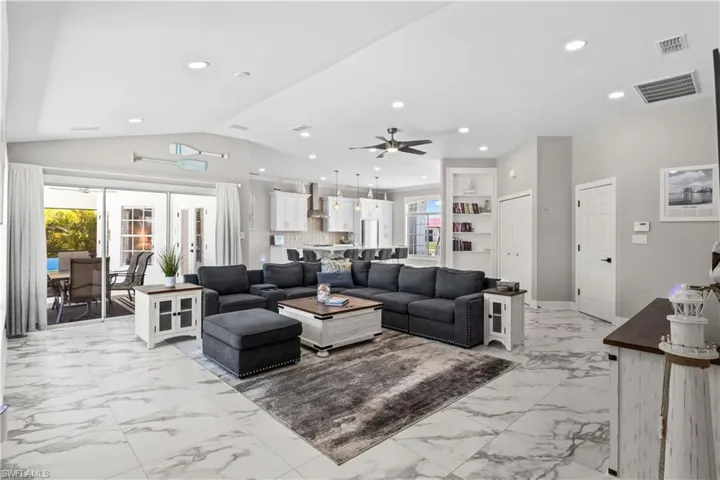 Living area with visible vents, ceiling fan, recessed lighting, and lofted ceiling