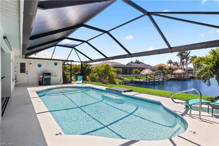 Pool with a water view, a patio area, a lanai, and area for grilling