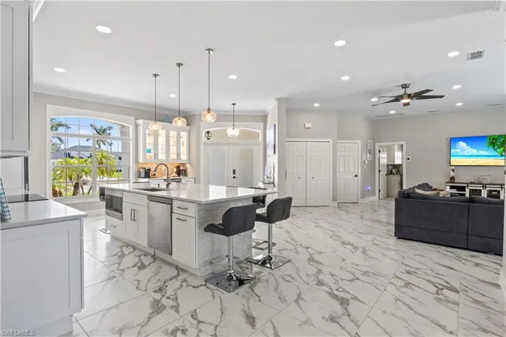 Kitchen with recessed lighting, light countertops, white cabinets, visible vents, and dishwasher