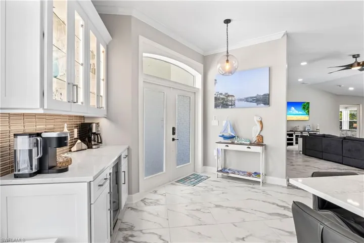 Foyer featuring baseboards, recessed lighting, crown molding, a ceiling fan, and marble finish floor