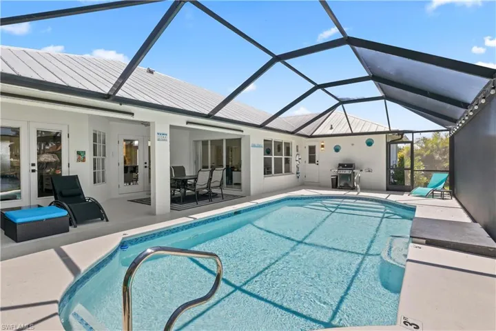 Outdoor pool featuring a patio area, grilling area, and a lanai