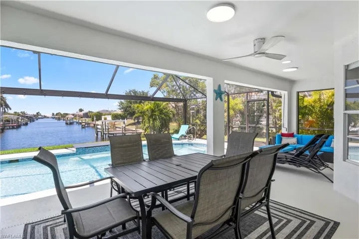 Sunroom featuring a water view, a pool, and ceiling fan