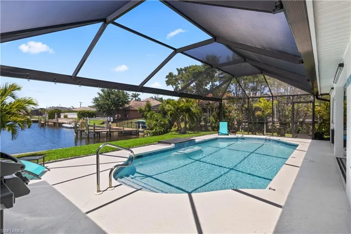 Pool with a water view, a patio area, and glass enclosure