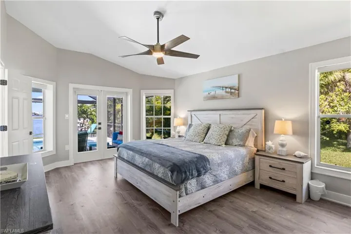 Bedroom featuring access to outside, french doors, wood finished floors, and multiple windows