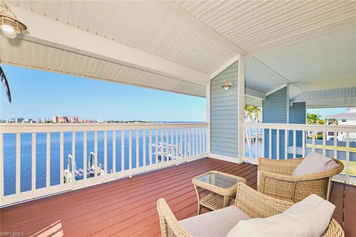 Primary bedroom - Wooden deck featuring a water view