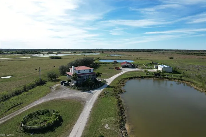 Birds eye view of property with a water view and a rural view