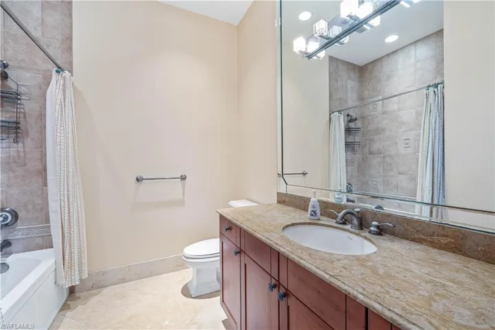 Full bathroom featuring tile patterned floors, shower / bath combo, toilet, and vanity