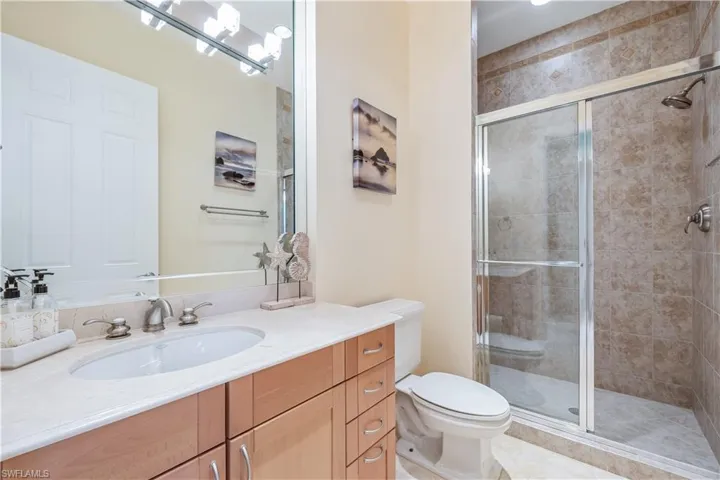 Bathroom with tile patterned floors, vanity, walk in shower, and toilet