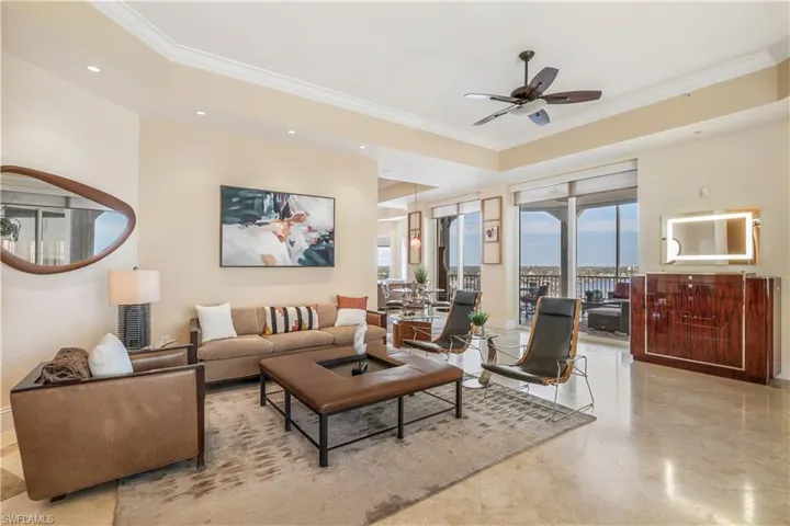 Living room with ceiling fan and ornamental molding
