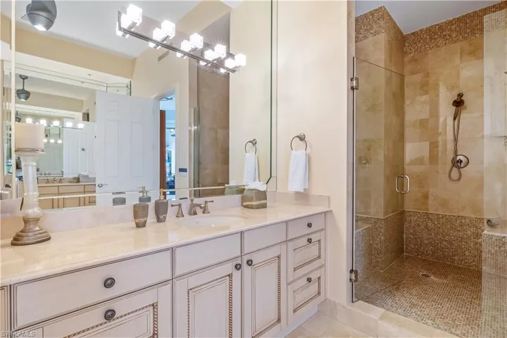 Bathroom featuring walk in shower, tile patterned floors, and vanity