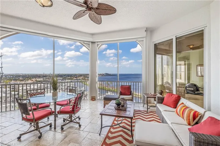 Sunroom featuring ceiling fan, a water view, and a healthy amount of sunlight