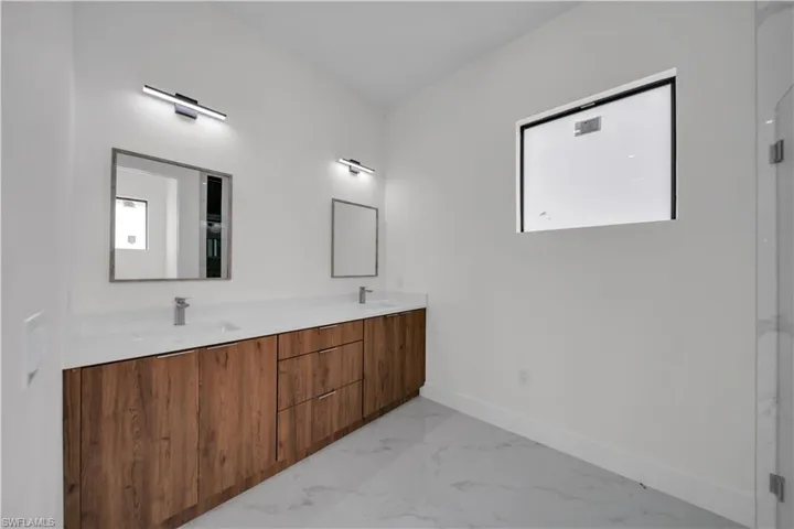 Full bathroom featuring marble finish flooring and double vanity