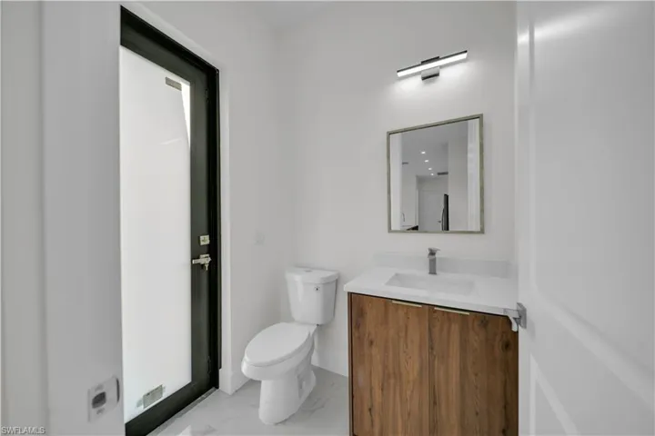Half bathroom featuring vanity and marble look tiles