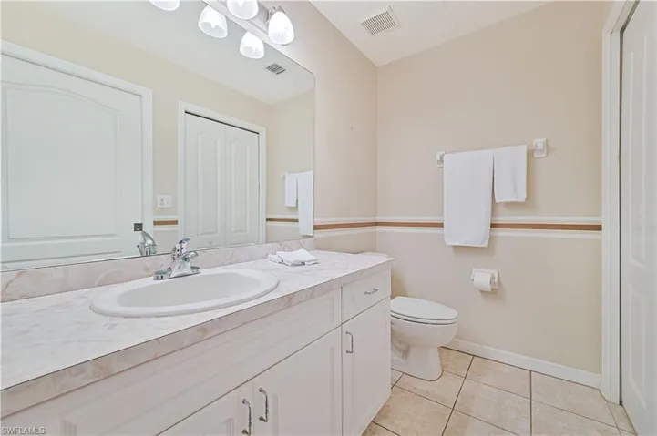 Bathroom with vanity, toilet, tile patterned floors, and baseboards