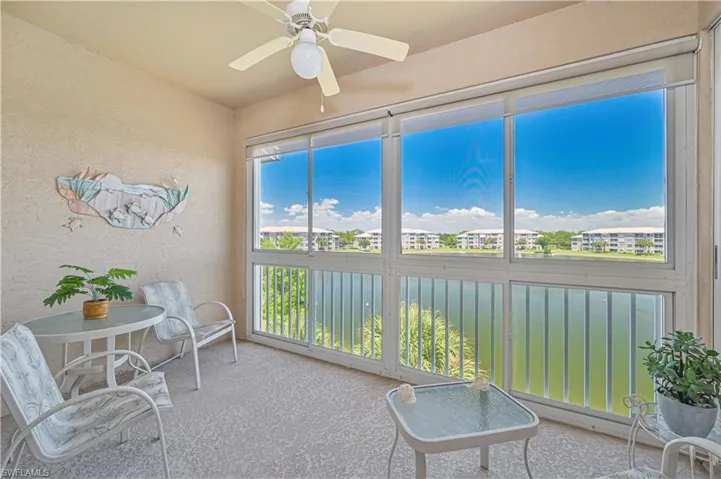 Sunroom featuring a ceiling fan and a water view