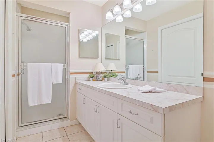 Bathroom featuring vanity, a shower stall, and tile patterned flooring
