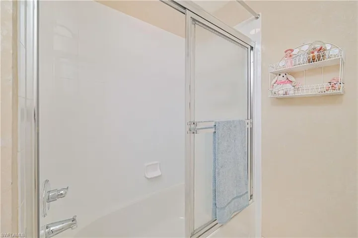 Bathroom with bath / shower combo with glass door