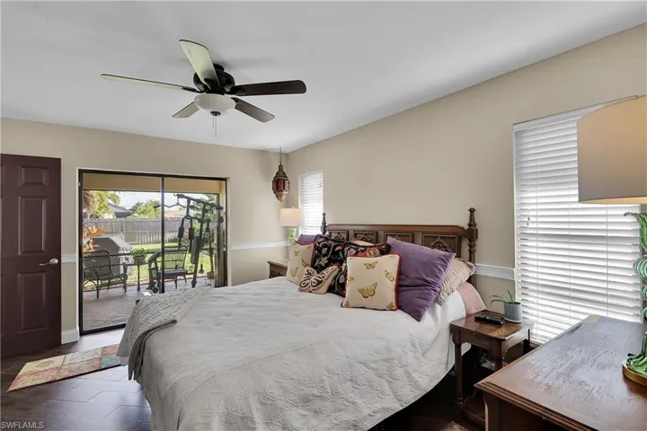 Bedroom featuring access to exterior, ceiling fan, and dark wood-style flooring
