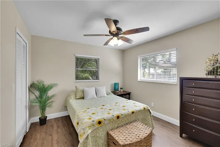 Bedroom with arched walkways, wood finished floors, and a ceiling fan