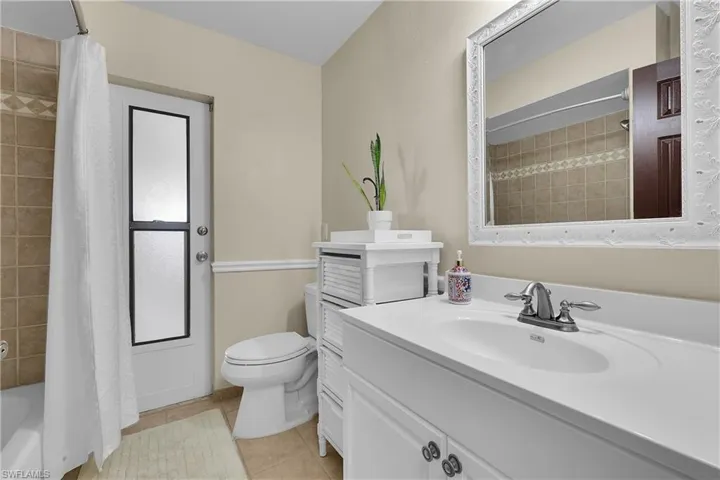 Bathroom featuring shower / bathtub combination, vanity, and light tile patterned flooring