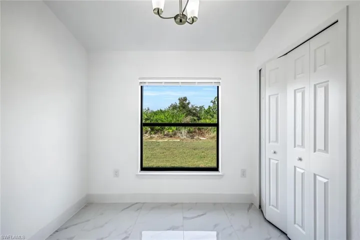 Versatile room with a vaulted/raised ceiling and marble floors—perfect for a bedroom, office, playroom, or den.