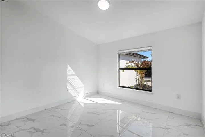 Spacious, sunlit room with tile flooring and a large window—easy to stage for multiple uses.