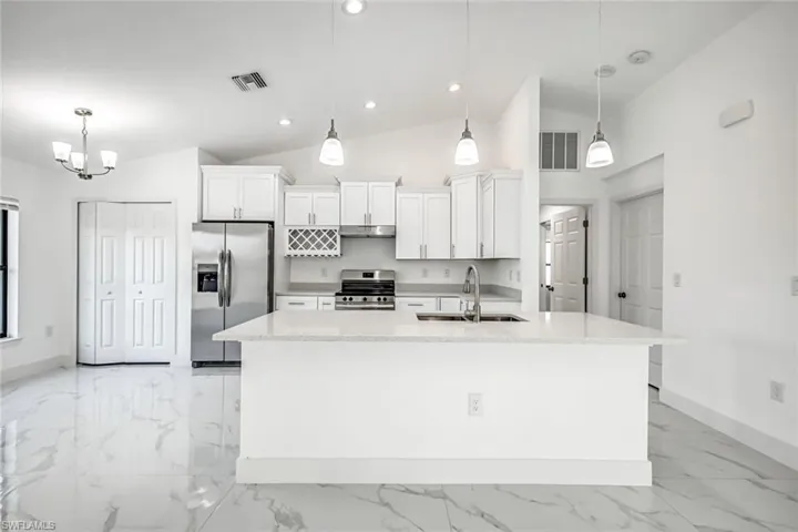 Large center island with seating potential, pendant lighting, and an open view to the main living area—ideal for entertaining.