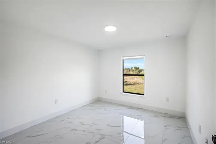 Another view of the same bright room emphasizing open floor space and natural light.