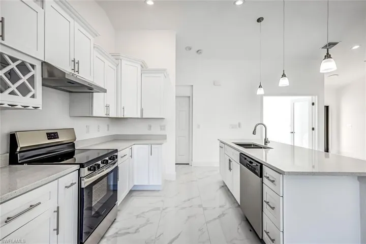 Streamlined kitchen design with stainless appliances, generous counters, and an open, connected flow to the main space.