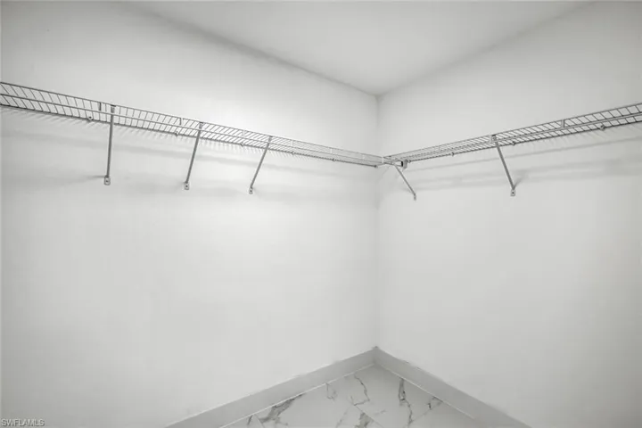 Large walk-in closet with built-in shelving/racks for organized storage and easy wardrobe setup.