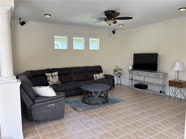 Living area featuring decorative columns, ceiling fan, ornamental molding, recessed lighting, and light tile patterned floors