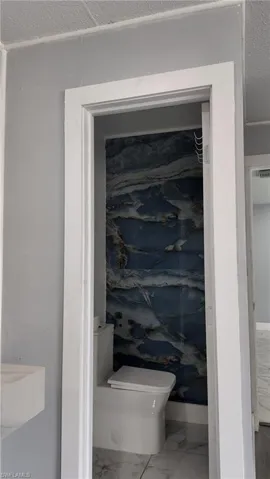 Bathroom view of toilet and a textured ceiling