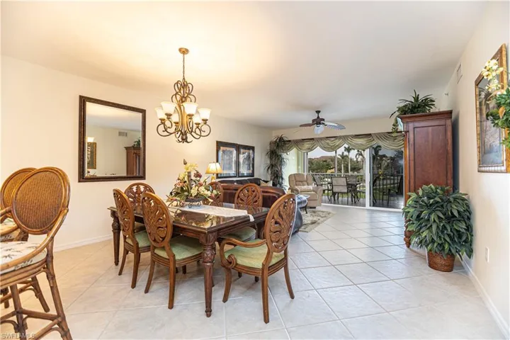 Dining space featuring light tile patterned floors, ceiling fan, and a chandelier