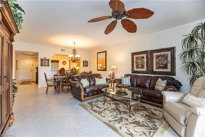 Living room with light tile patterned flooring, a chandelier, and a ceiling fan