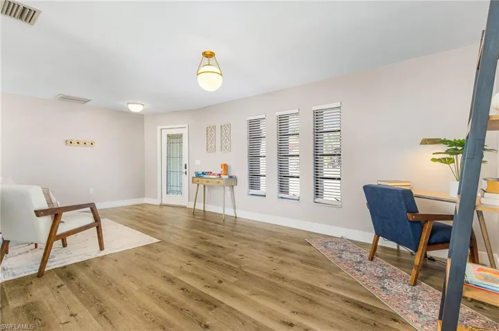 Sitting room with baseboards, light wood-type flooring, and visible vents