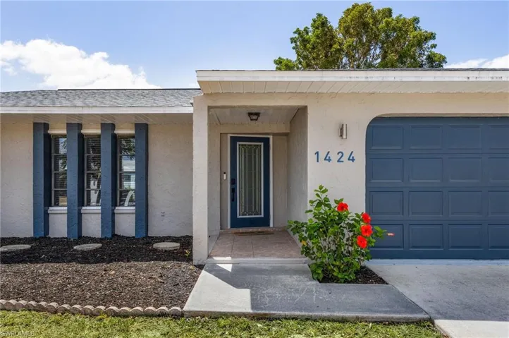 Doorway to property with stucco siding and an attached garage