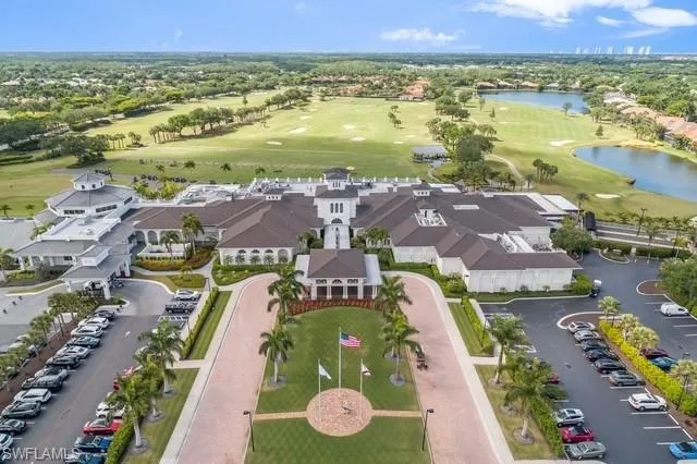 Shadow Wood Country Club, with flagpoles in front of main entrance and practice driving range just beyond building, first fairway of south course to extreme left. Finishing hole #18 to right.